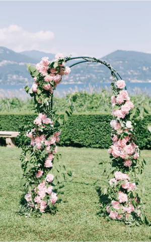 Outdoor wedding ceremony arch covered in pink and white roses